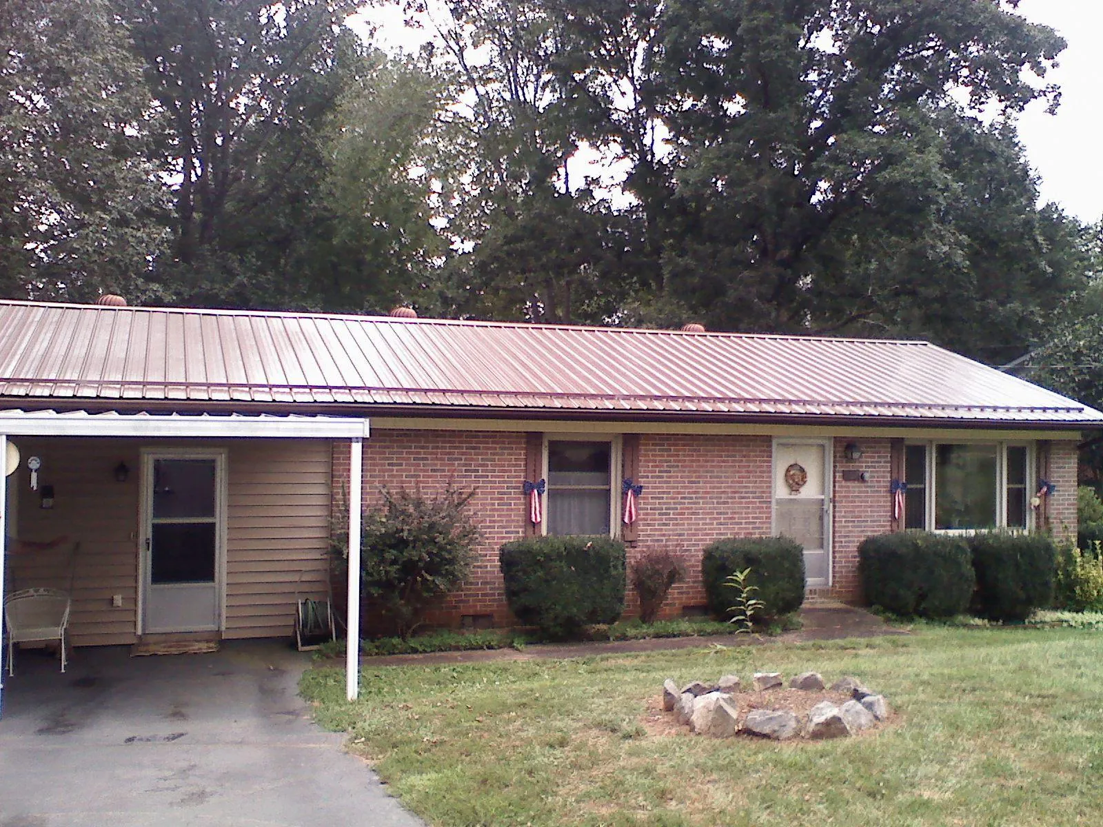 Bronze metal roof and carport on a brick ranch home — Roof Repair work by our crew in Commerce Township