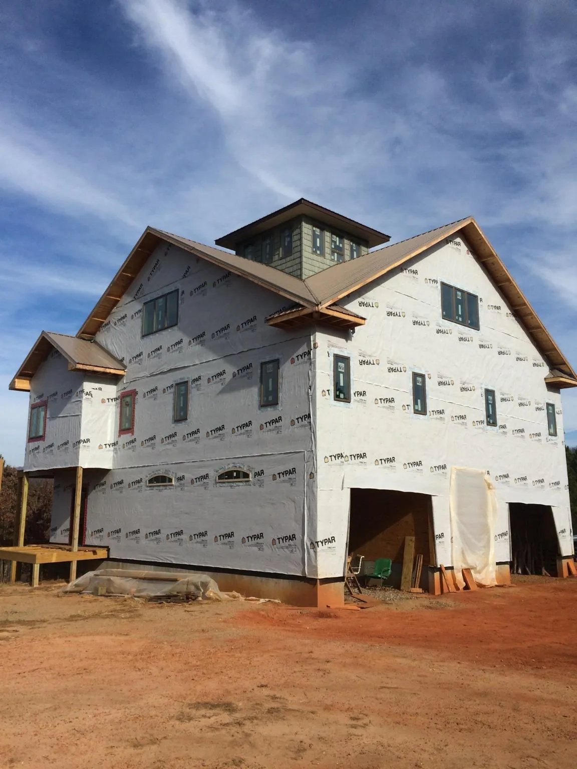 New two story house under construction with a cupola and gabled roofs in Commerce Township